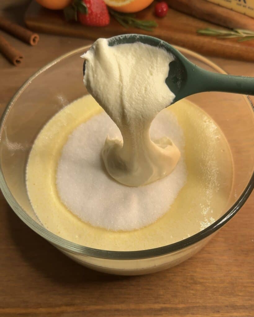 Combining the cornstarch mixture with heavy cream in a bowl, mixing together to create a creamy filling for Churro cheesecake bars
