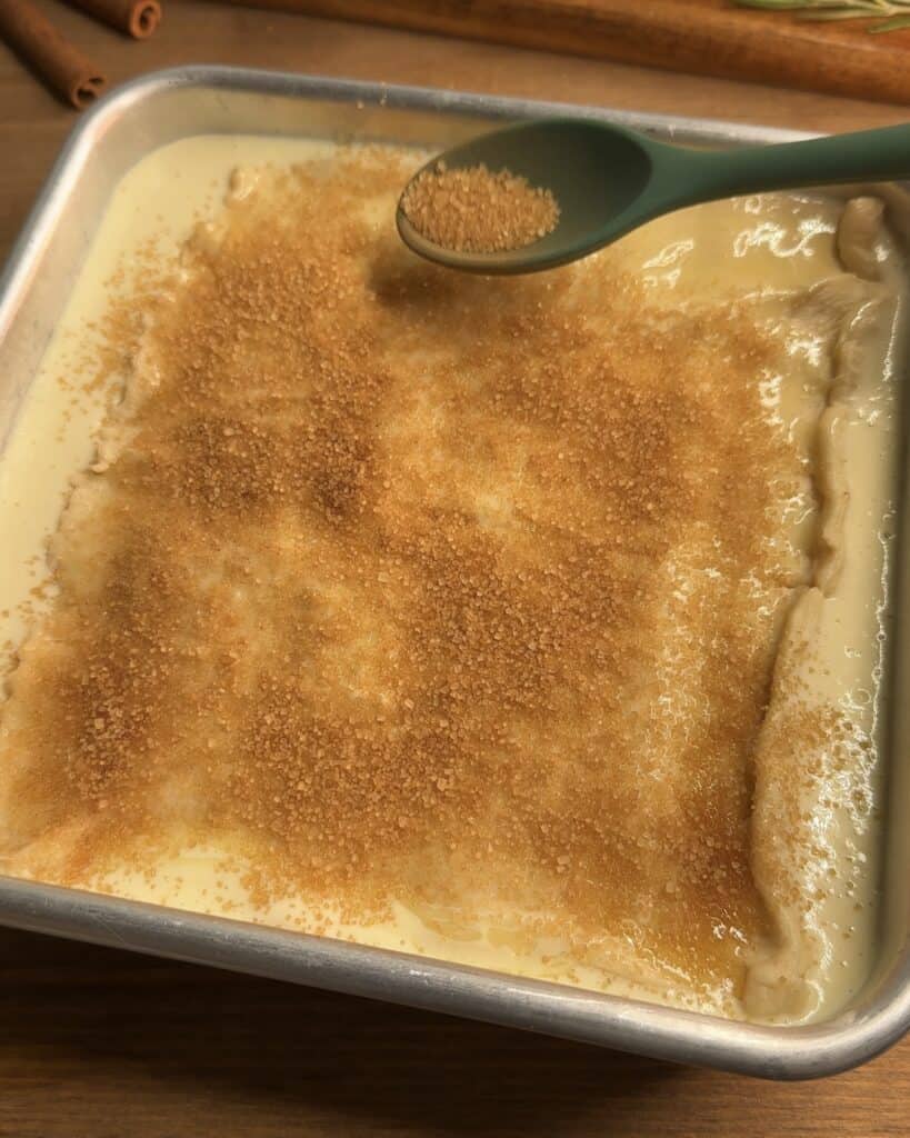 Sprinkling brown sugar and cinnamon on top of the Churro cheesecake bars for added flavor and texture