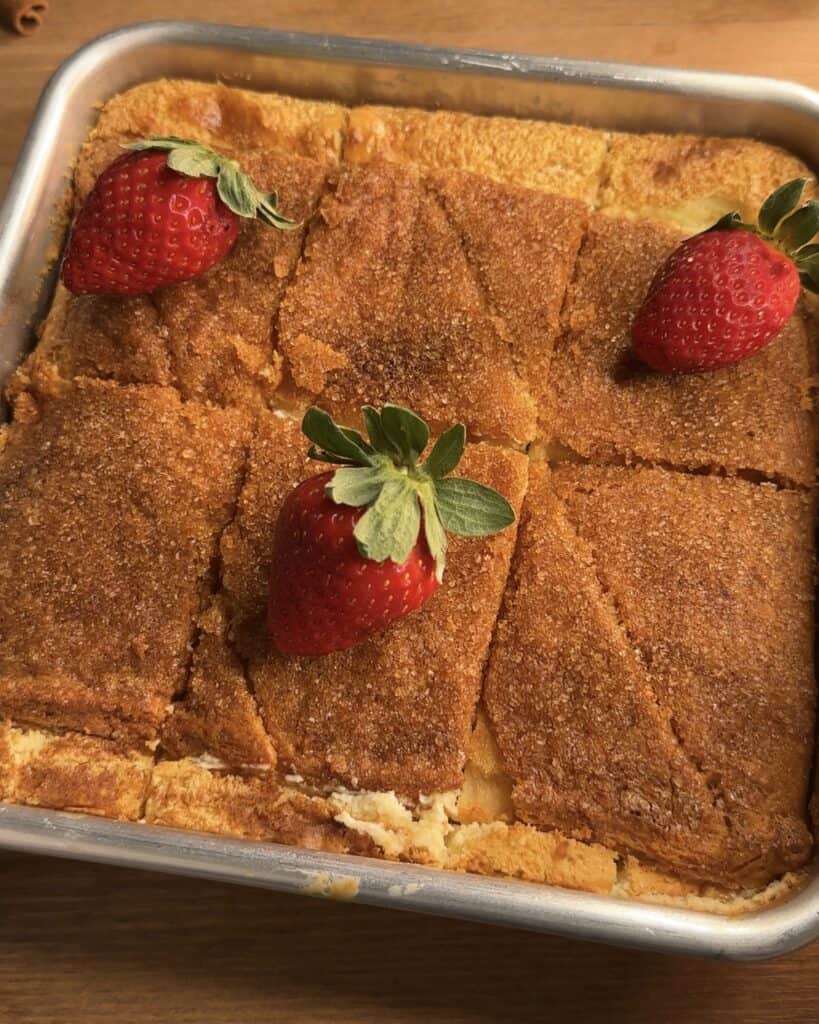 Churro cheesecake bars with a crunchy exterior coated in sugar, cinnamon, and butter, and a smooth, creamy cheesecake interior