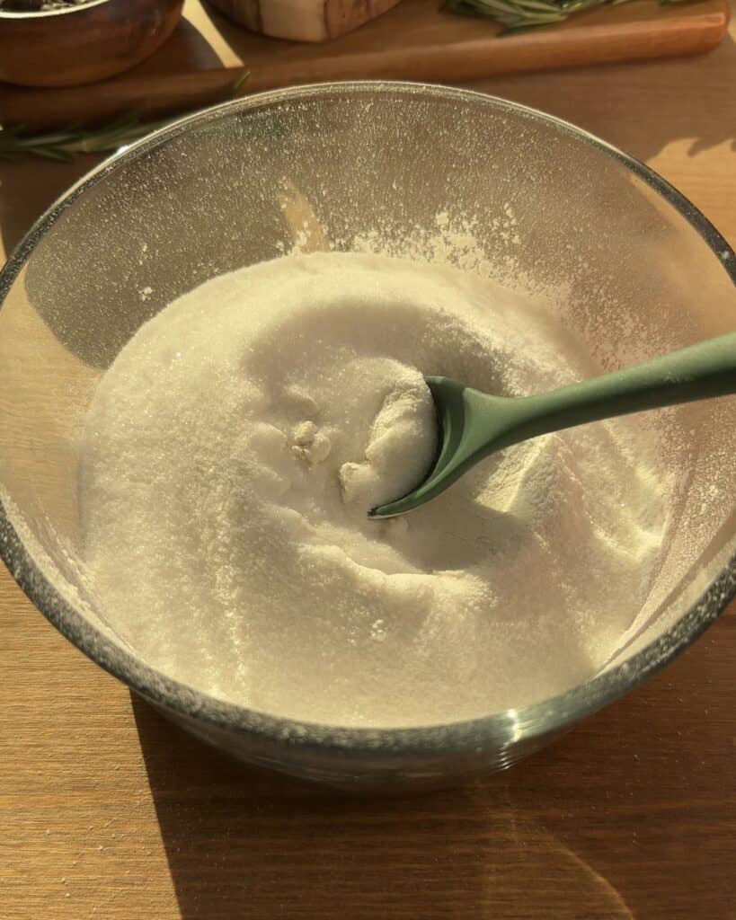 Whisking all-purpose flour, sugar, and baking powder in a mixing bowl to make the Cookie Dough Muffins with chocolate