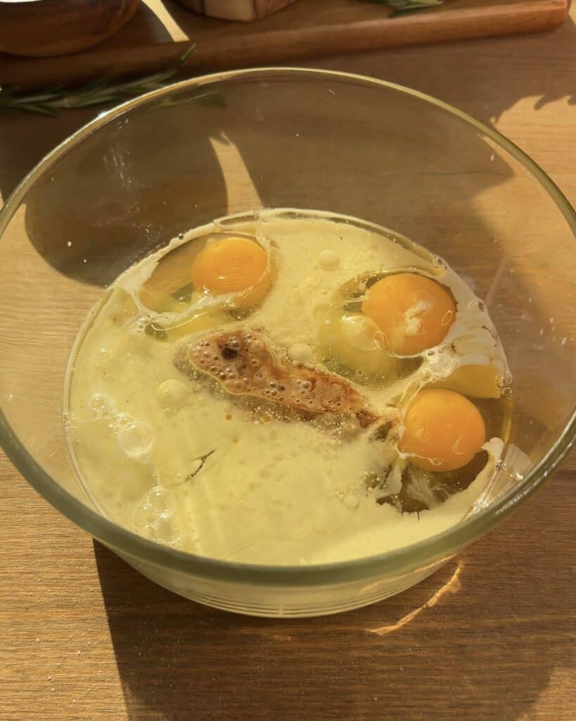 Whisking eggs, oil, milk, and vanilla extract in a bowl to create a smooth mixture for Cookie Dough Muffins with chocolate