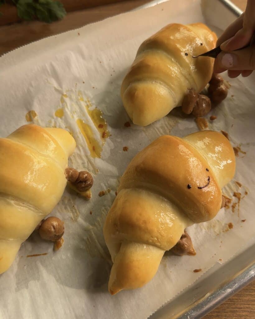 Freshly baked Jellycat croissant, golden brown and ready to eat, with a flaky, buttery texture