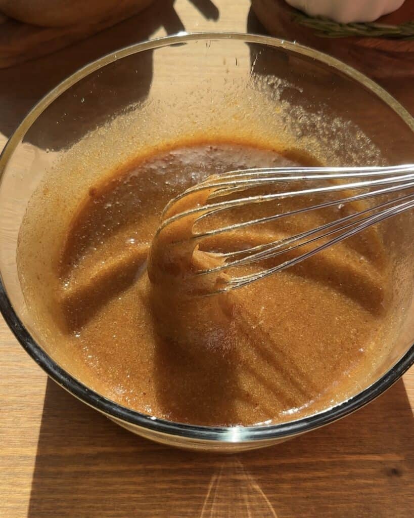 Mixing sugar with eggs and sunflower oil in a bowl to prepare the batter for a Carrot Cake Christmas Recipe