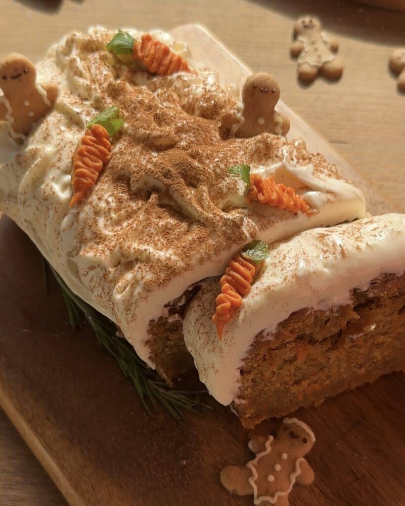 Carrot cake topped with gingerbread cookies, cinnamon and a decorative chocolate carrot