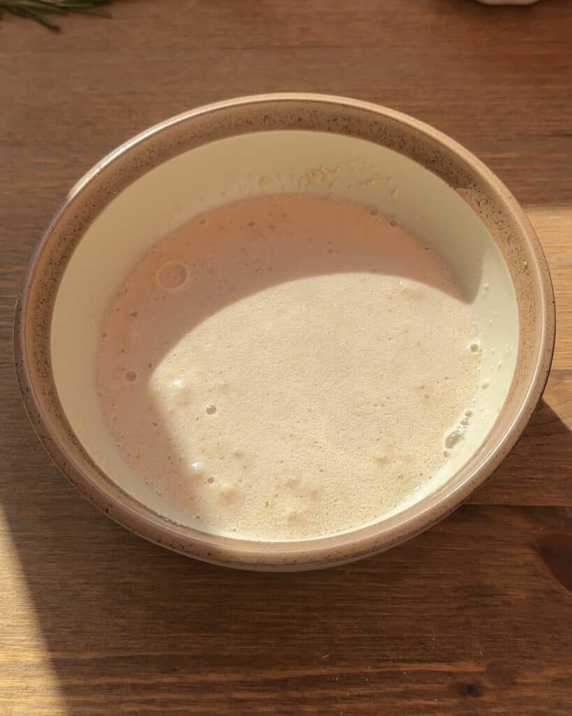 Smooth sponge mixture prepared to begin making the dough, forming the base for a soft and fluffy bread