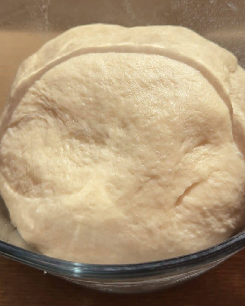 Proofed dough, doubled in size, ready to be shaped and baked into a festive pull-apart Christmas tree garlic bread.