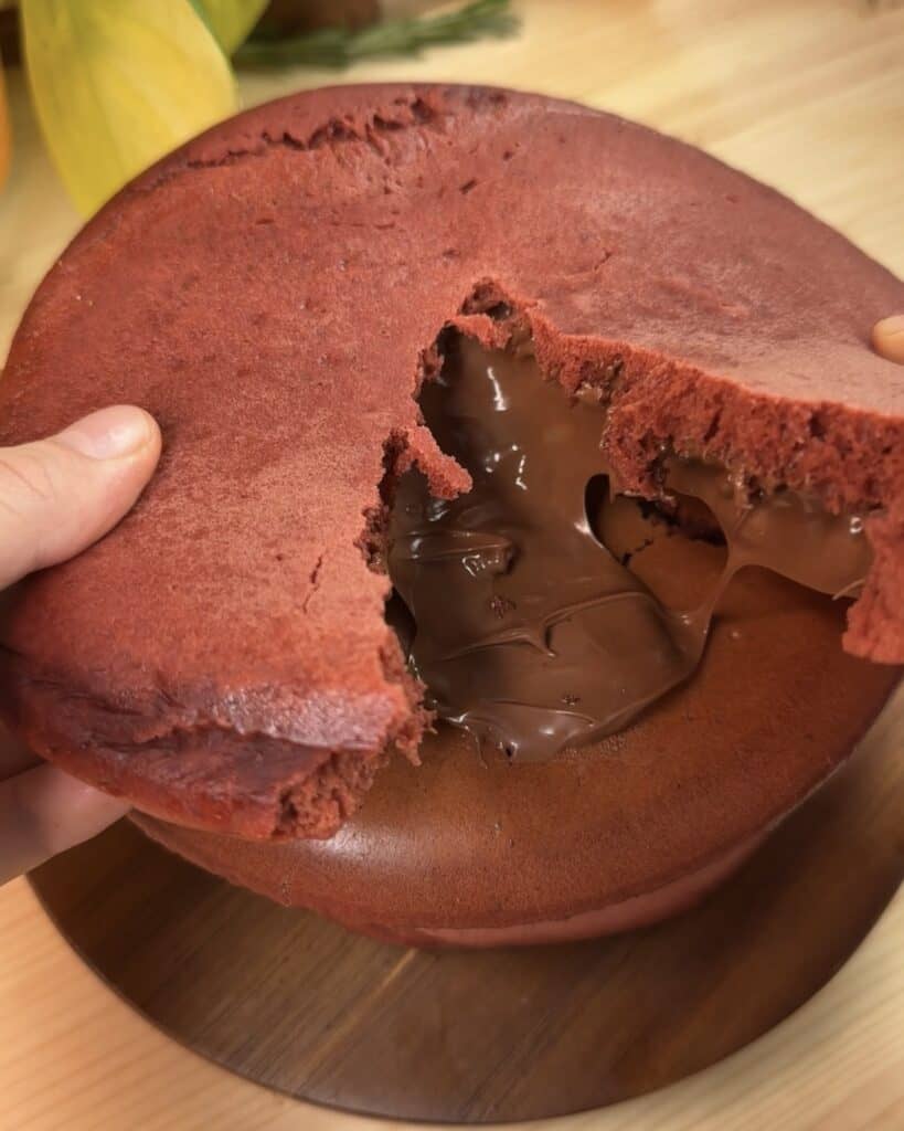 Red velvet Nutella stuffed pancake being cut open, revealing the gooey Nutella filling inside, creating a rich and indulgent dessert or breakfast treat