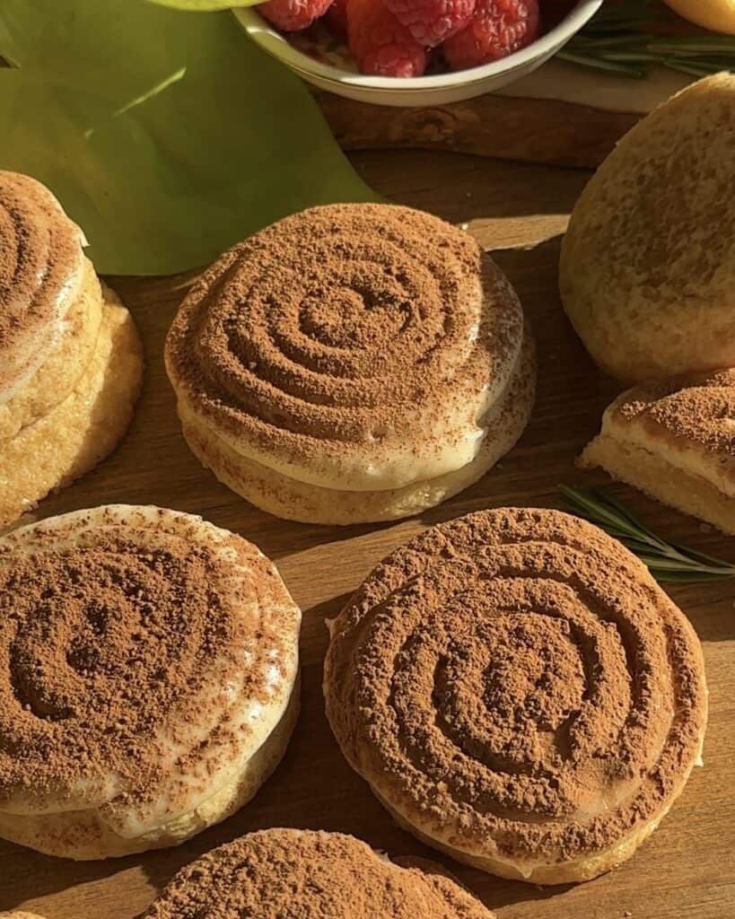 A close up of tiramisu inspired cookies with cocoa powder dusting on top placed on a wooden surface
