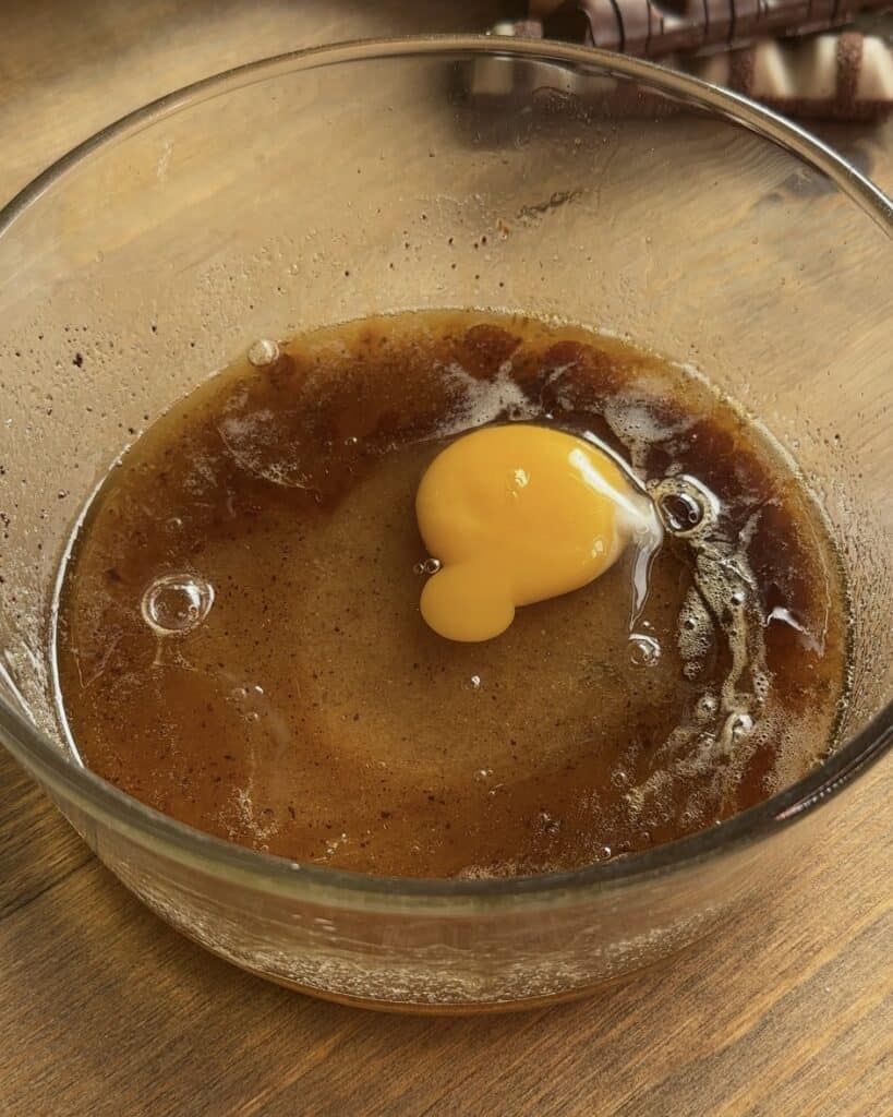 Brown butter mixed with granulated sugar and brown sugar in a bowl, creating a rich and smooth base for Kinder Bueno cookies.