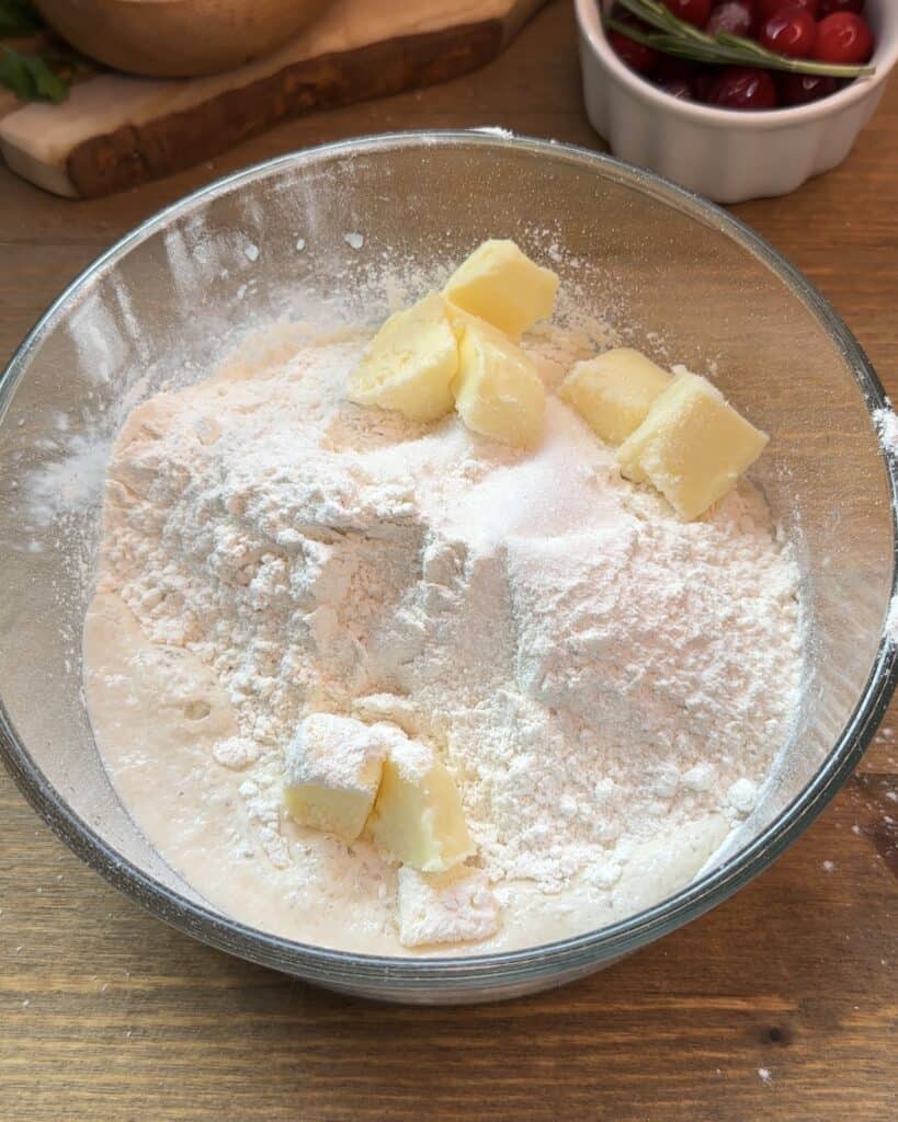 Pizza dough ingredients including flour, butter, salt, and sugar mixed together before kneading to create a soft and flavorful dough for chicken pizza
