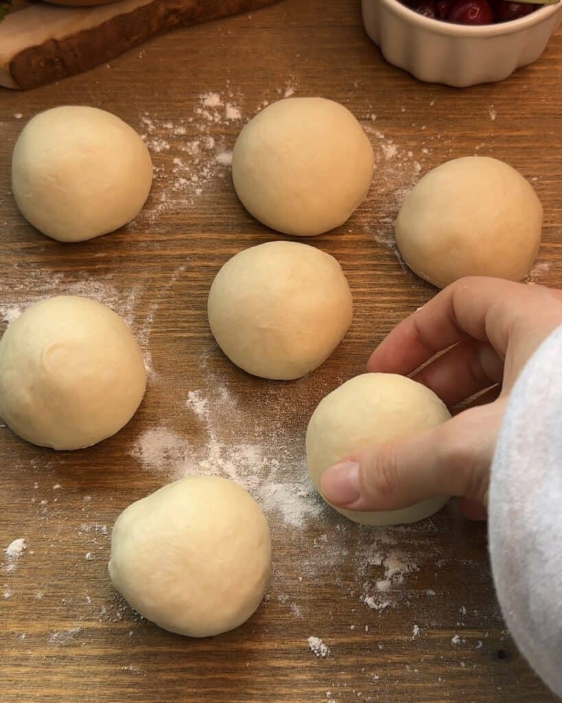 Mini pizza dough balls perfectly portioned and ready to be rolled out into thin crusts