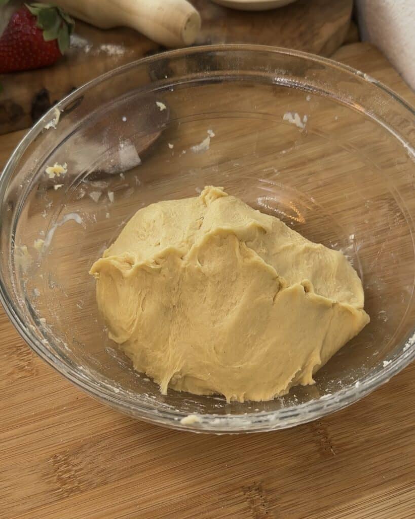 Kneaded Nutella Bomb Donut dough in a bowl, about to be proofed for 1 hour and 30 minutes, showing a smooth texture ready to rise and become fluffy.