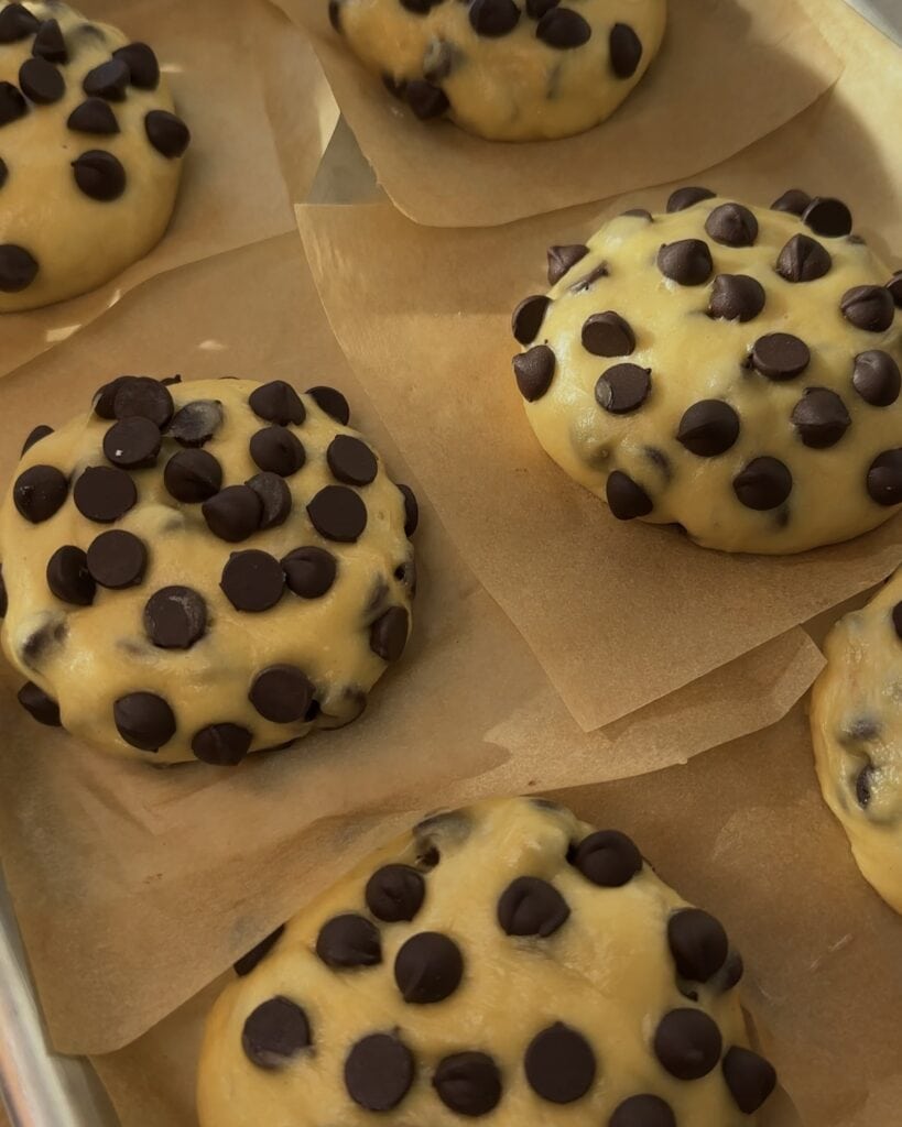 Proofed and shaped Nutella Bomb Donut dough, with visible chocolate chips throughout, ready for frying to create soft, fluffy donuts filled with Nutella.