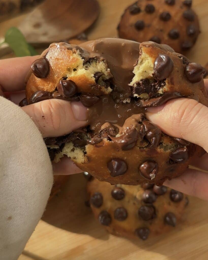 Nutella Bomb Donut opened in half, revealing a rich, gooey Nutella filling in the center, showcasing the soft, fluffy texture of the donut.