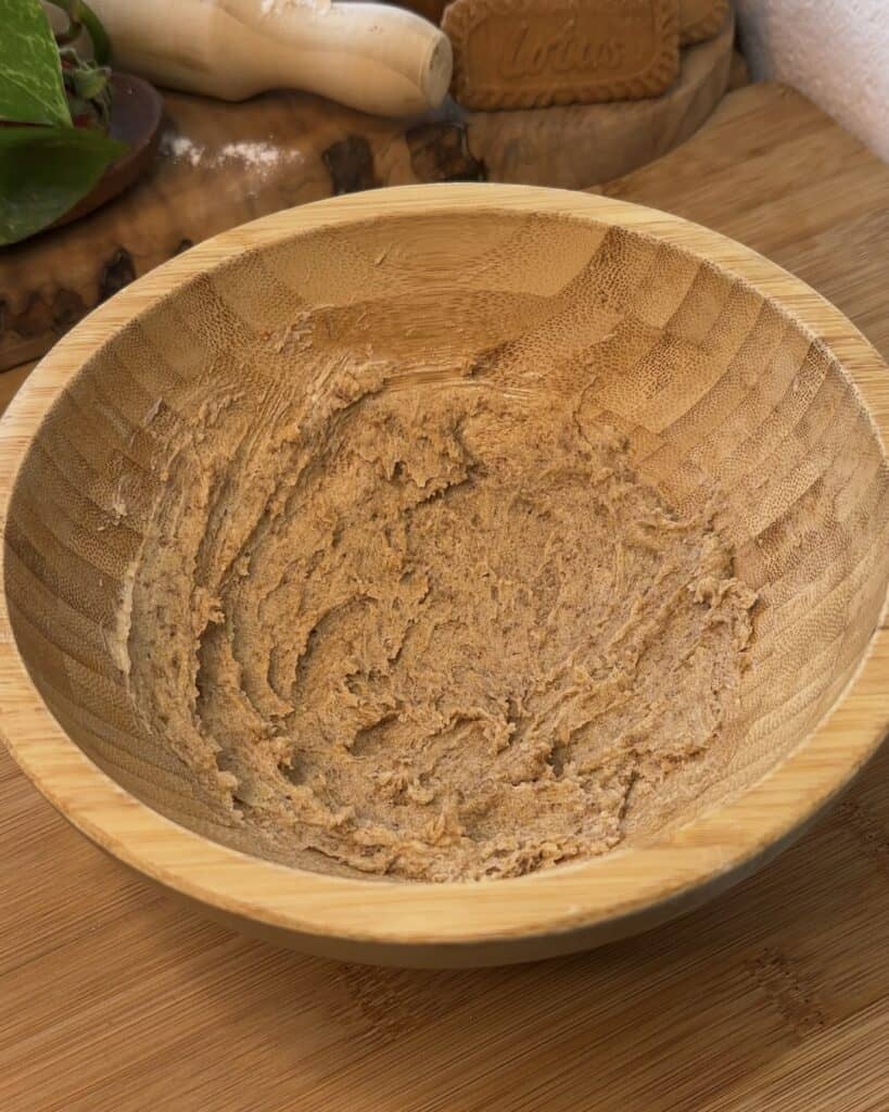 Image of a wooden bowl with softened butter, granulated sugar, brown sugar, and an egg mixed together, forming a smooth, fluffy texture for the Biscoff marshmallow stuffed cookie dough.