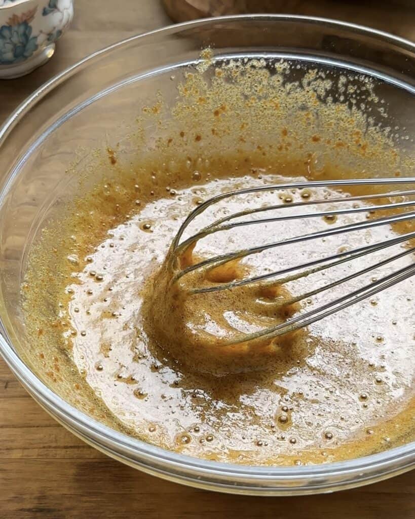 Bowl with sugars, eggs, vanilla, and brown butter mixed together for the cookie dough Nutella pie.