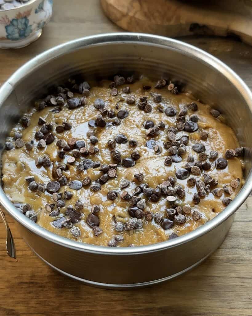 Unbaked cookie dough pie with a layer of Nutella in the center, ready to be baked