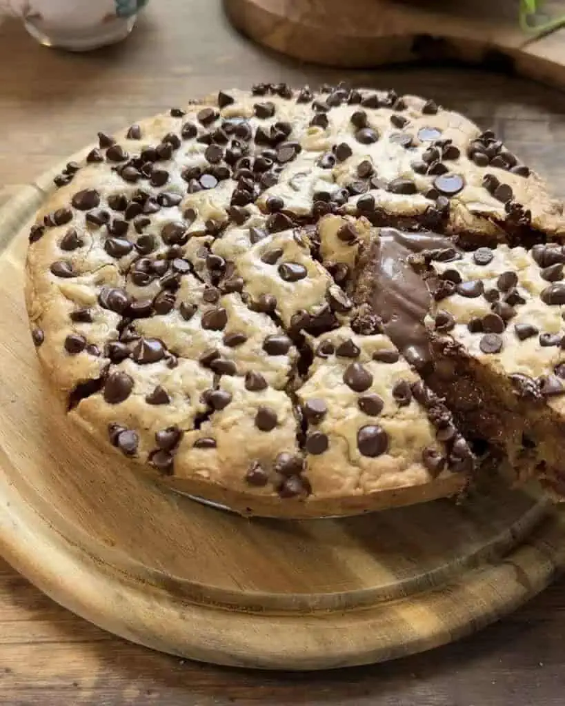 Cookie dough pie baked to golden perfection with a slice cut, revealing the creamy Nutella center.