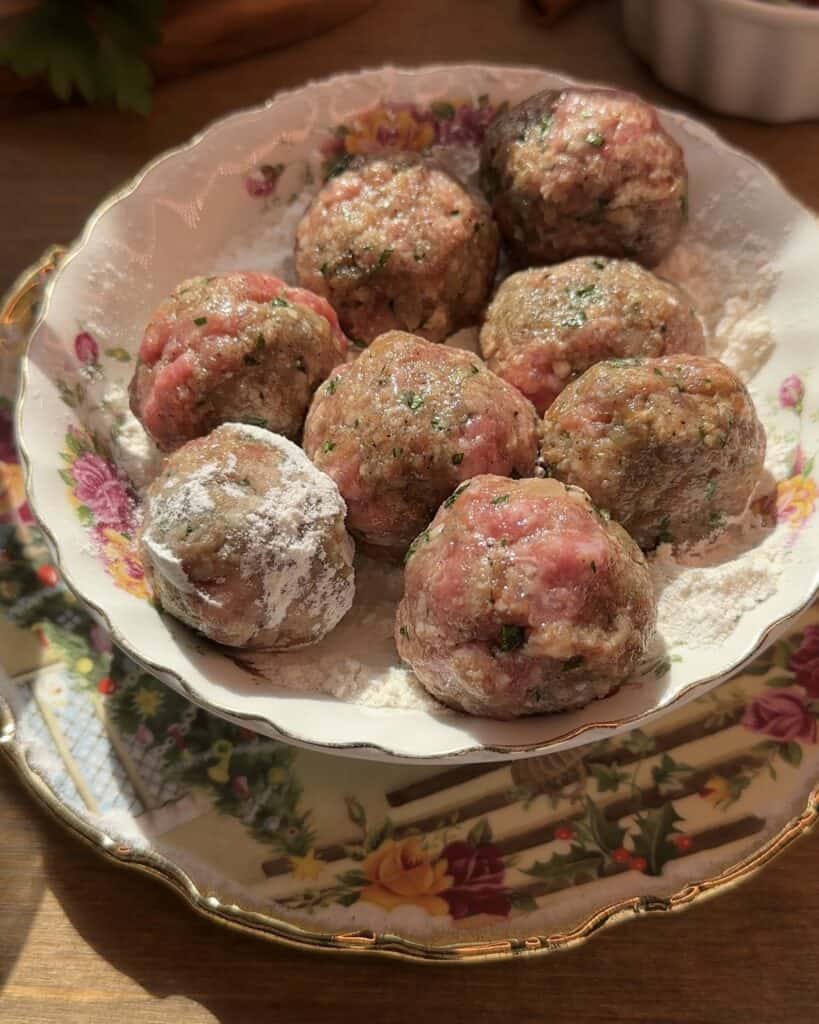 Raw meatballs arranged neatly on a plate, ready to be cooked.