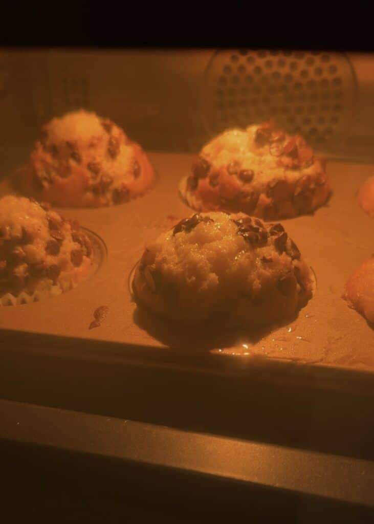 Nutella muffins baking in the oven, showing golden tops and gooey centers.