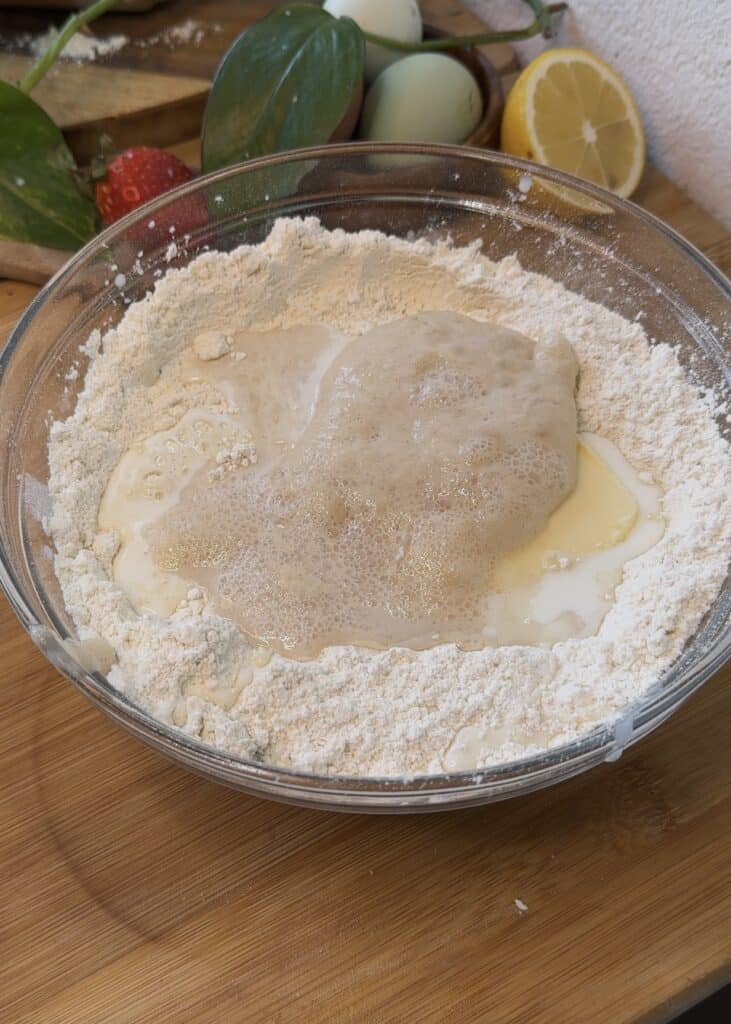 Bowl of dough ingredients with activated yeast mixture on top, ready for kneading Nutella heart donut dough.