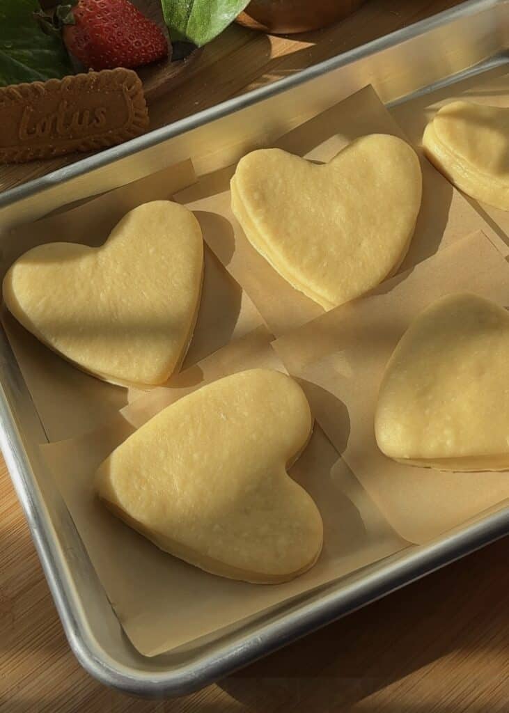 Cut Nutella heart donuts in a pan waiting to proof before baking