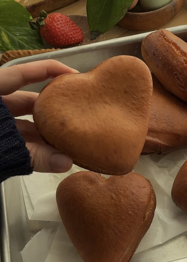 Golden-brown heart-shaped Nutella donut freshly fried, ready to be filled and coated for Valentine’s Day.