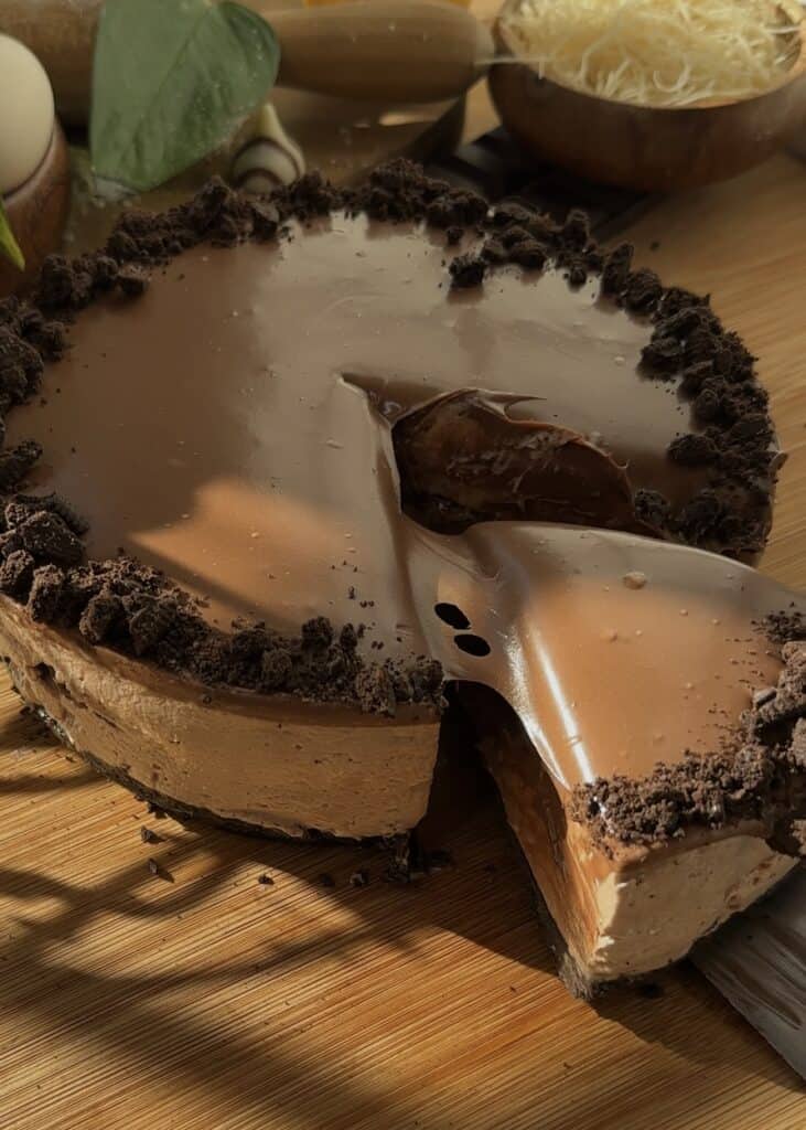 Whole no-bake Nutella cheesecake with a slice cut.