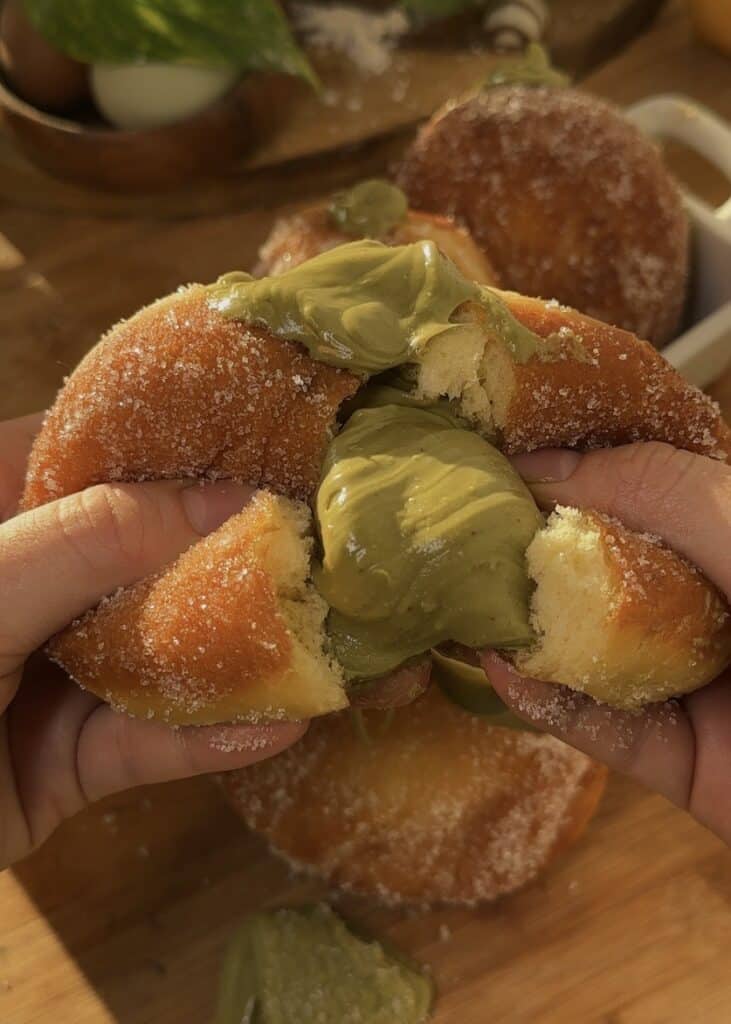 Fluffy pistachio donut opened to show creamy pistachio filling