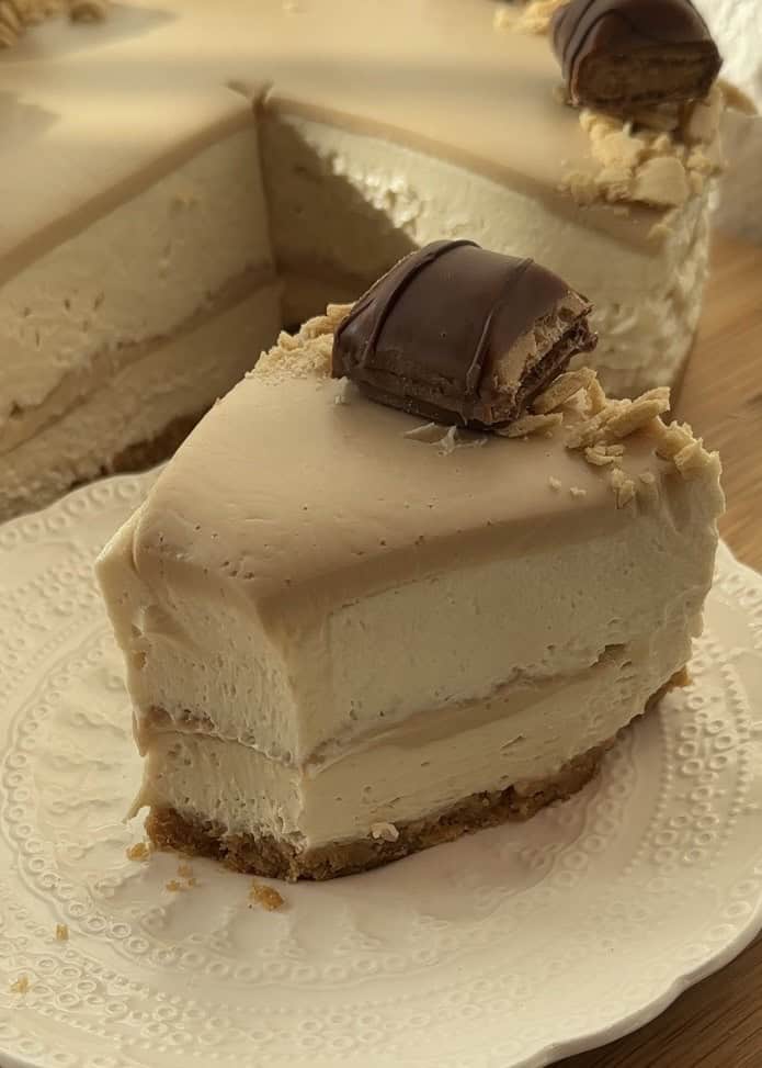 A slice of no-bake Kinder Bueno cheesecake after the second bite, showcasing its creamy texture and stunning layers.