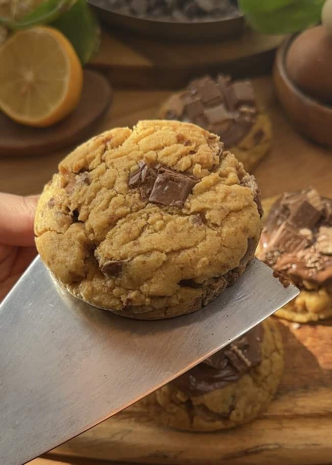 Freshly baked Copycat Crumbl KitKat cookies with a soft, gooey texture and melted KitKat pieces inside, just out of the oven.