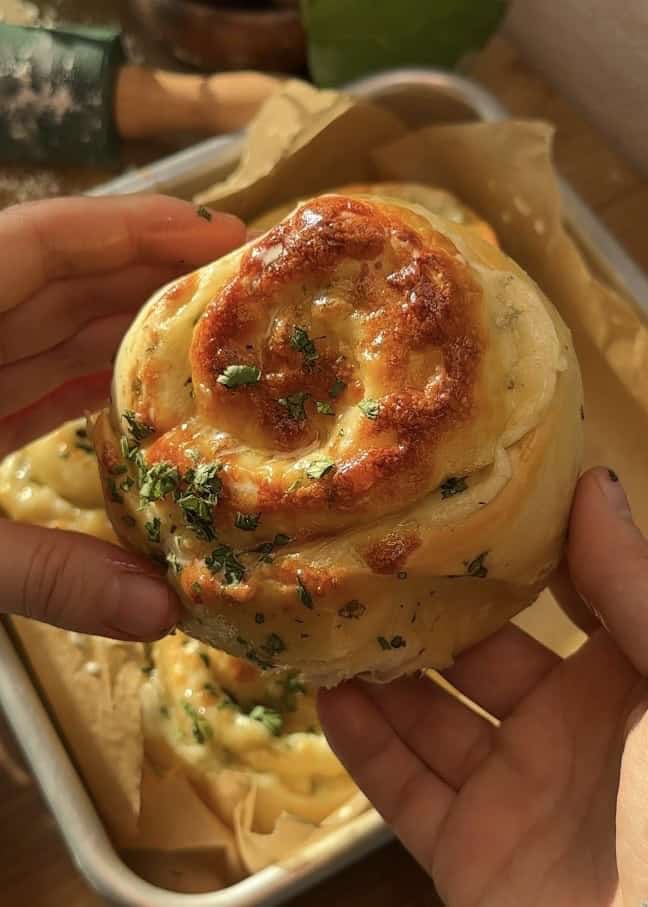 Close-up of a buttery cheese garlic roll, soft, fluffy, and filled with melted, bubbly mozzarella cheese.
