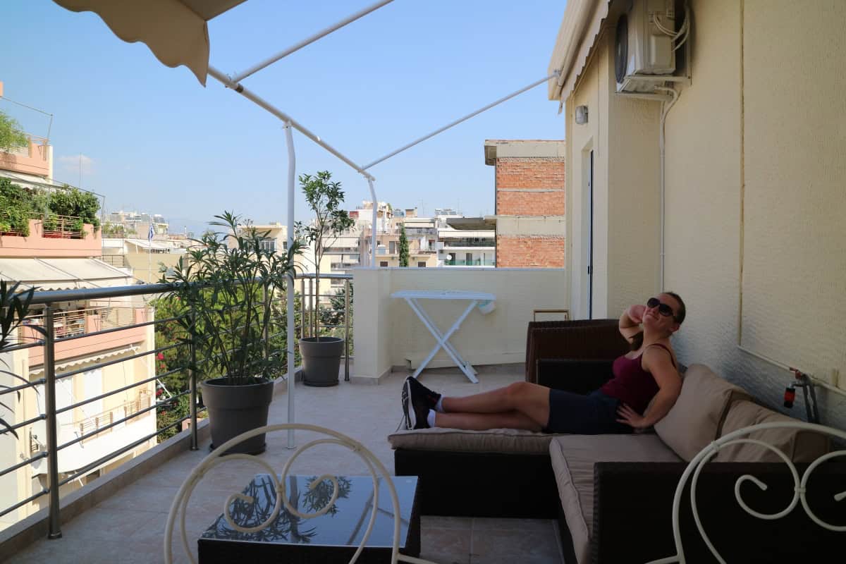 Sophie reclining on a sofa on a balcony.