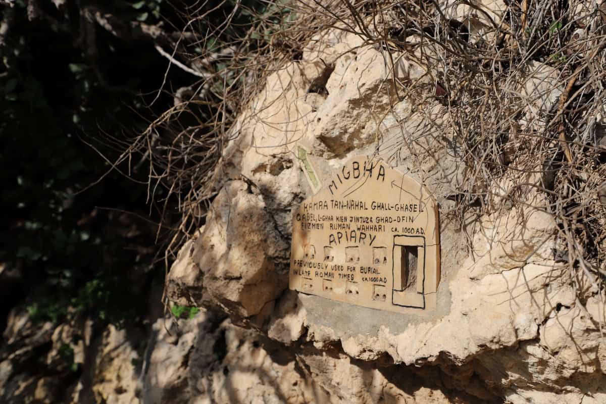 Ancient burial site marker on rocky ground with handwritten notes about the site and its historical significance.