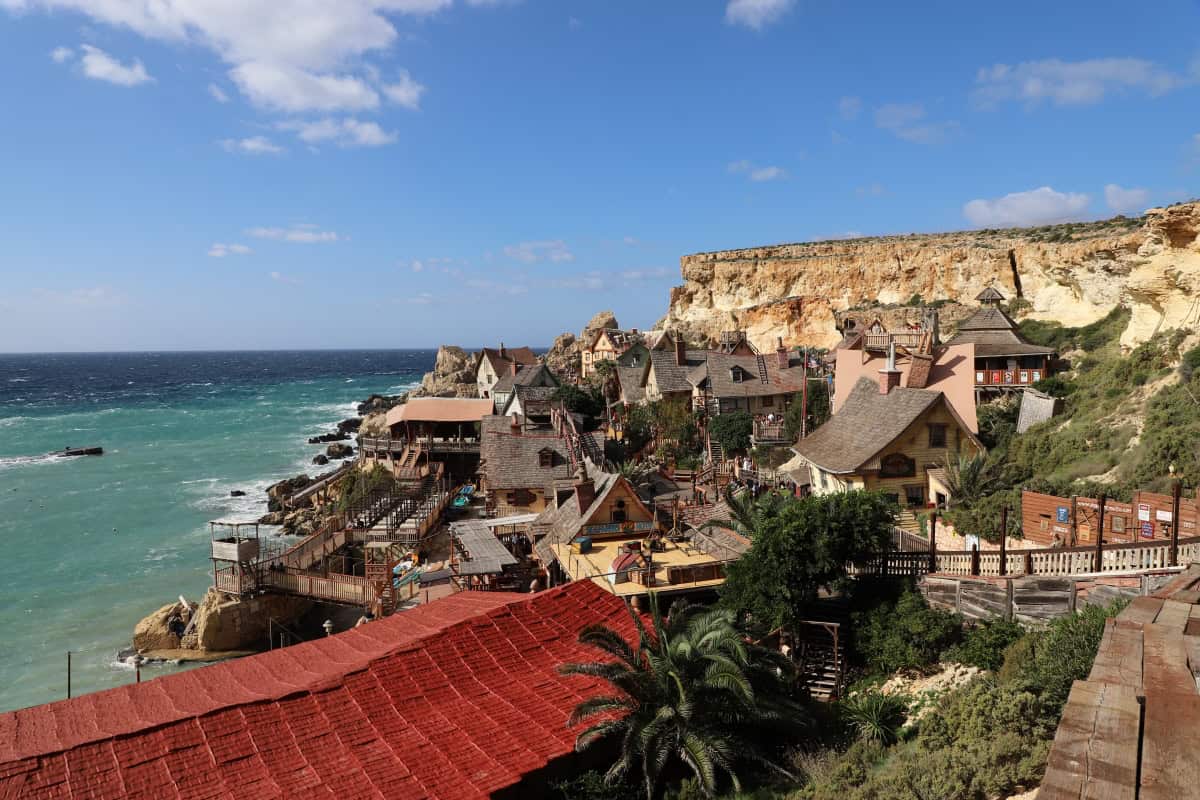 Cliffside beach town with colourful houses and turquoise ocean views, popular coastal destination.