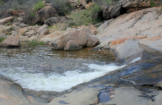 A small falls feeding the Devil's Hole at Inks Lake State Park - Texas Hill Country - Two Worlds Treasures
