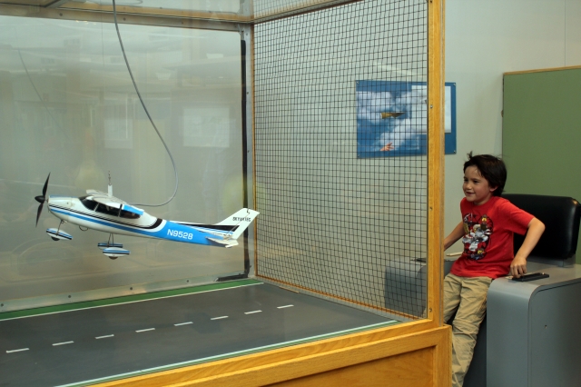 Flying an airplane in Explora, the Children Museum in Albuquerque, NM. (Two Worlds Treasures)