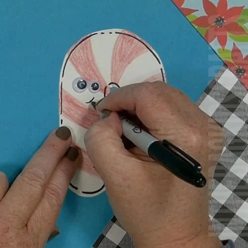A colorful Christmas craft featuring a simple candy cane craft, perfect as an easy craft for kids during the holiday season.  Step 4 add details to the candy cane. 