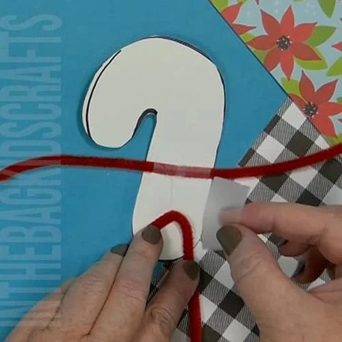A colorful Christmas craft featuring a simple candy cane craft, perfect as an easy craft for kids during the holiday season.  Step 5 adding the arms and legs to the candy cane. 