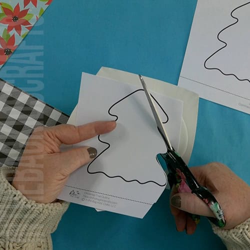 A completed Christmas tree craft made with green paper, colorful beads, pipe cleaners, and a star topper, perfect as an easy craft for kids and a festive Christmas tree craft.  step 2 cutting out the christmas tree 