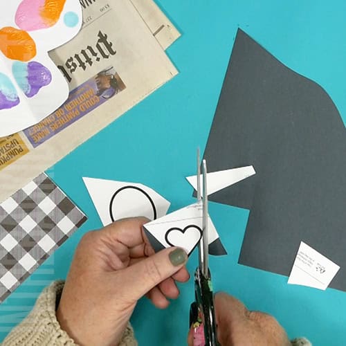 An image showing a colorful paper skull craft for kids, perfect as a Day of the Dead craft activity.  step 4 cutting out the nose and eyes 