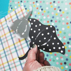 A hand holds a spotted paper stingray craft, perfect for an ocean crafts for kids activity and an easy paper craft project.