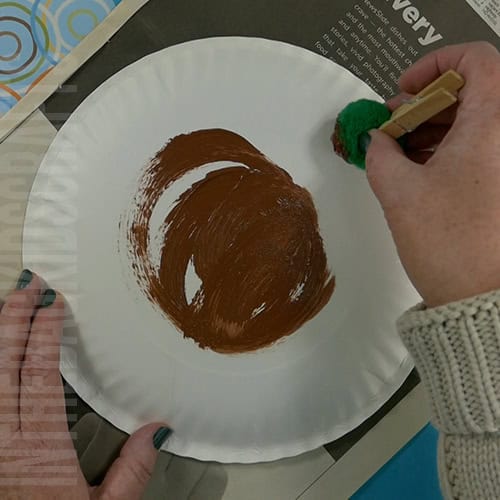 An adorable bear craft for kids made from a painted paper plate, featuring a hibernating animal design. step 1