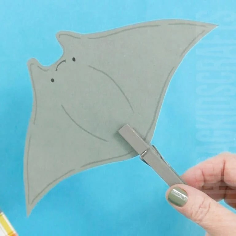 A simple manta ray craft for kids made from gray paper and a clothespin, perfect as a fun and interactive ocean craft for little ones.