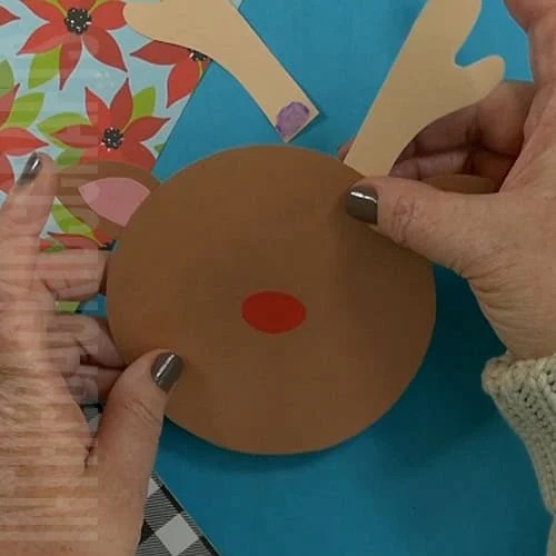 A DIY reindeer card featuring a fun and festive design, perfect as a Christmas card or Christmas craft for kids to create their own personalized holiday greetings.  Step 3 gluing the pieces together 