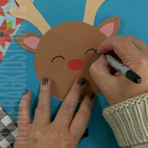 A DIY reindeer card featuring a fun and festive design, perfect as a Christmas card or Christmas craft for kids to create their own personalized holiday greetings.  step 4 adding the face and other details 