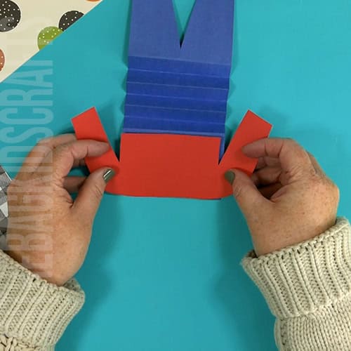 An image showing a paper scarecrow craft, perfect as an easy fall craft for kids to enjoy making.