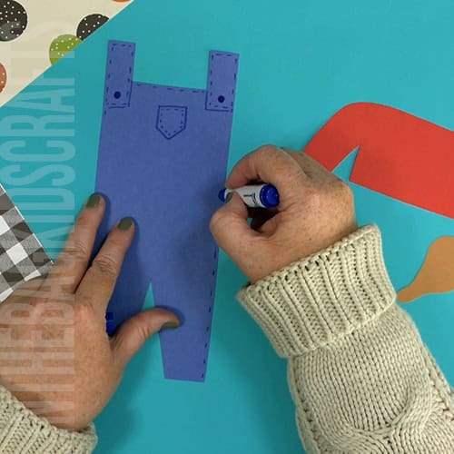 An image showing a paper scarecrow craft, perfect as an easy fall craft for kids to enjoy making.