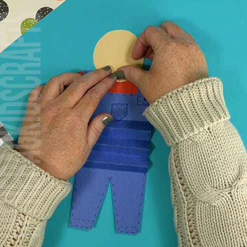 An image showing a paper scarecrow craft, perfect as an easy fall craft for kids to enjoy making.