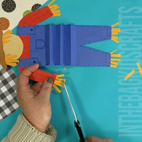 An image showing a paper scarecrow craft, perfect as an easy fall craft for kids to enjoy making.